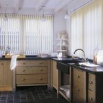 simple and elegant kitchen design with vertical white blind and rustic wooden cbainetry and black tile flooring