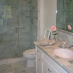 Shower Area With Glass Door And Ming Green Marble Tile With White Cabinet