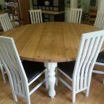 Wooden 8 Person Round Dining Table With White Bases And White Chairs