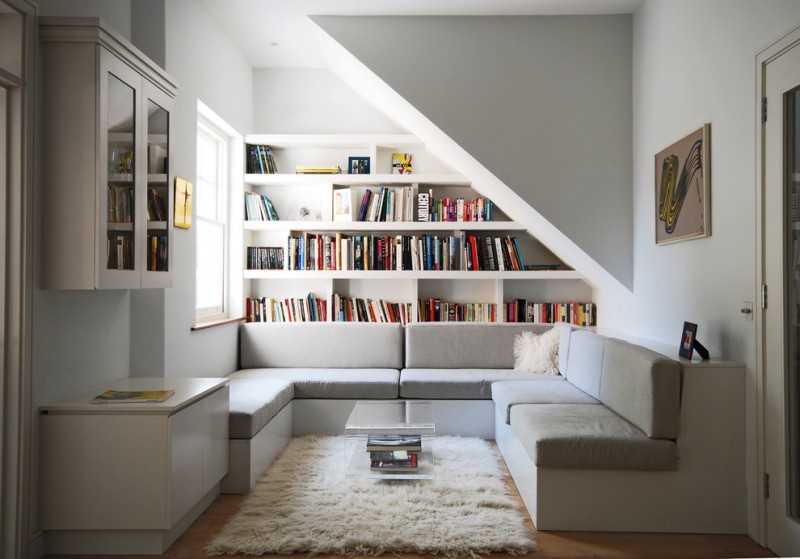 small contemporary reading nook U shaped sectional in white large book shelves medium sized fluffy rug in white