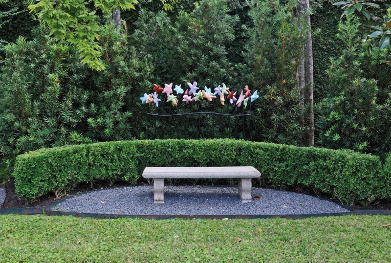 seating corner concrete made bench with curved greens fences colorful stars shaped garden lamps