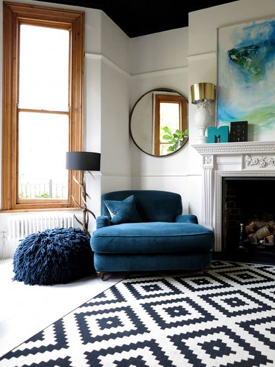 classic loveseat in navy blue fury pouch in navy blue black white area rug in modern patterns black framed wall mirror in circle shape