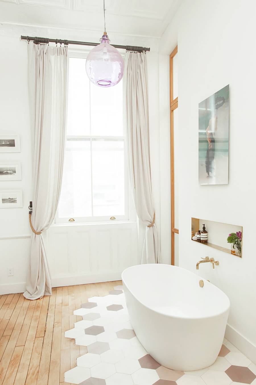 quirky bathroom design longer curtains with tiedback rope glass pendant light sleek bathtub in white geometric tile floor accent on light wood floors modern artwork