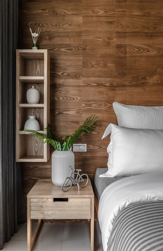 wood wall vertical wood storage unit wooden bedside table white bed linen white pillowcases striped duvet cover