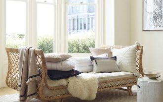 rattan daybed with throw pillows tufted upholstery and throw blanket
