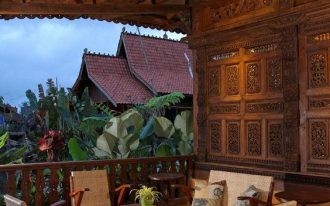 tropical style balcony wicker chairs from Indonesia Batik area rug wood carved wall panel from Indonesia exposed wood beams wood railing system