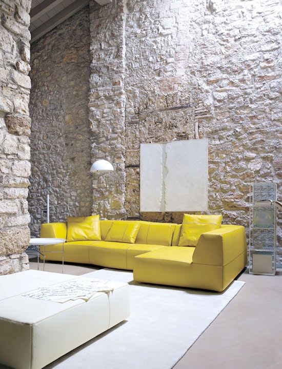 hard textured stoned walls modern minimalist sofa in yellow white area rug