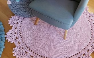 round shaped crochet rug in baby pink decorated with half way flower edges midcentury modern armchair in soft blue ornate crochet basket