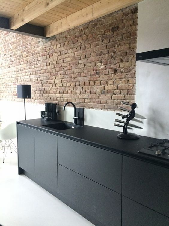 red brick wall highlight featuring white painted walls clean line and elegant black cabinets and countertop