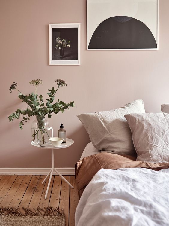 dusty pink wall white bedside table light tone bedding treatment wall decors dominated by black wood plank floors
