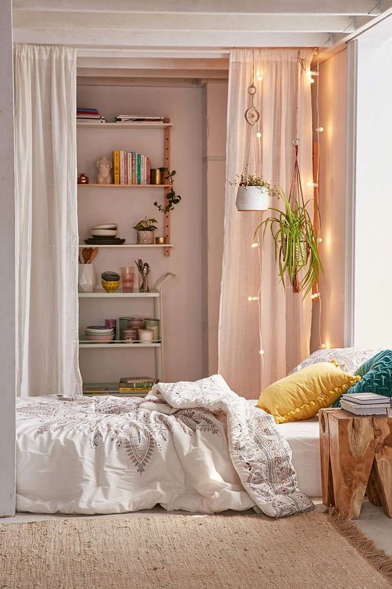 floor bed setting with colorful pillows white bed shirt and white quilt cover dramatic white textile room partition with accent lighting addition and hanging plants