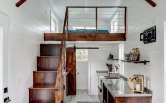 tiny house design dark finished wood staircase railings kitchen counter and beams purely white ceilings and walls whitewashed wood floors