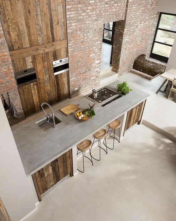 industrial style kitchen and eat in kitchen with concrete countertop industrial bar stools with round wood top brick walls rustic wood cabinets