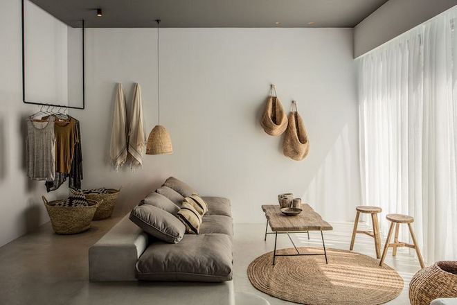 Wabi sabi living room idea with gray floor cushions rough wood top coffee table flat woven rug in round shape light wood stools
