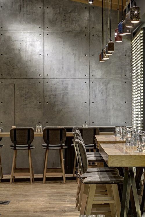 interior cafe with beton wall panels modern industrial stools wooden tables